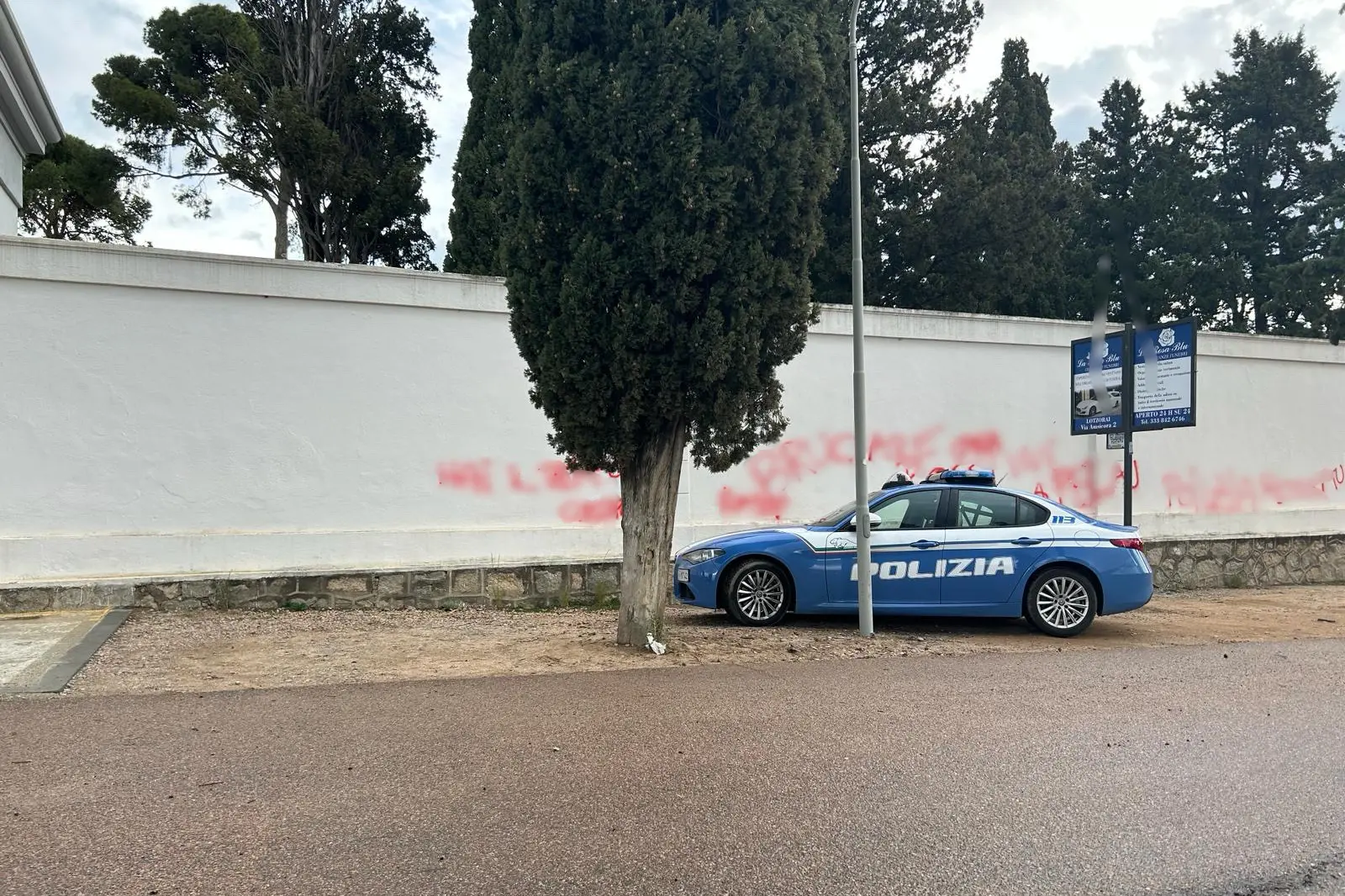 La Volante della polizia davanti al muro imbrattato (L'Unione Sarda)