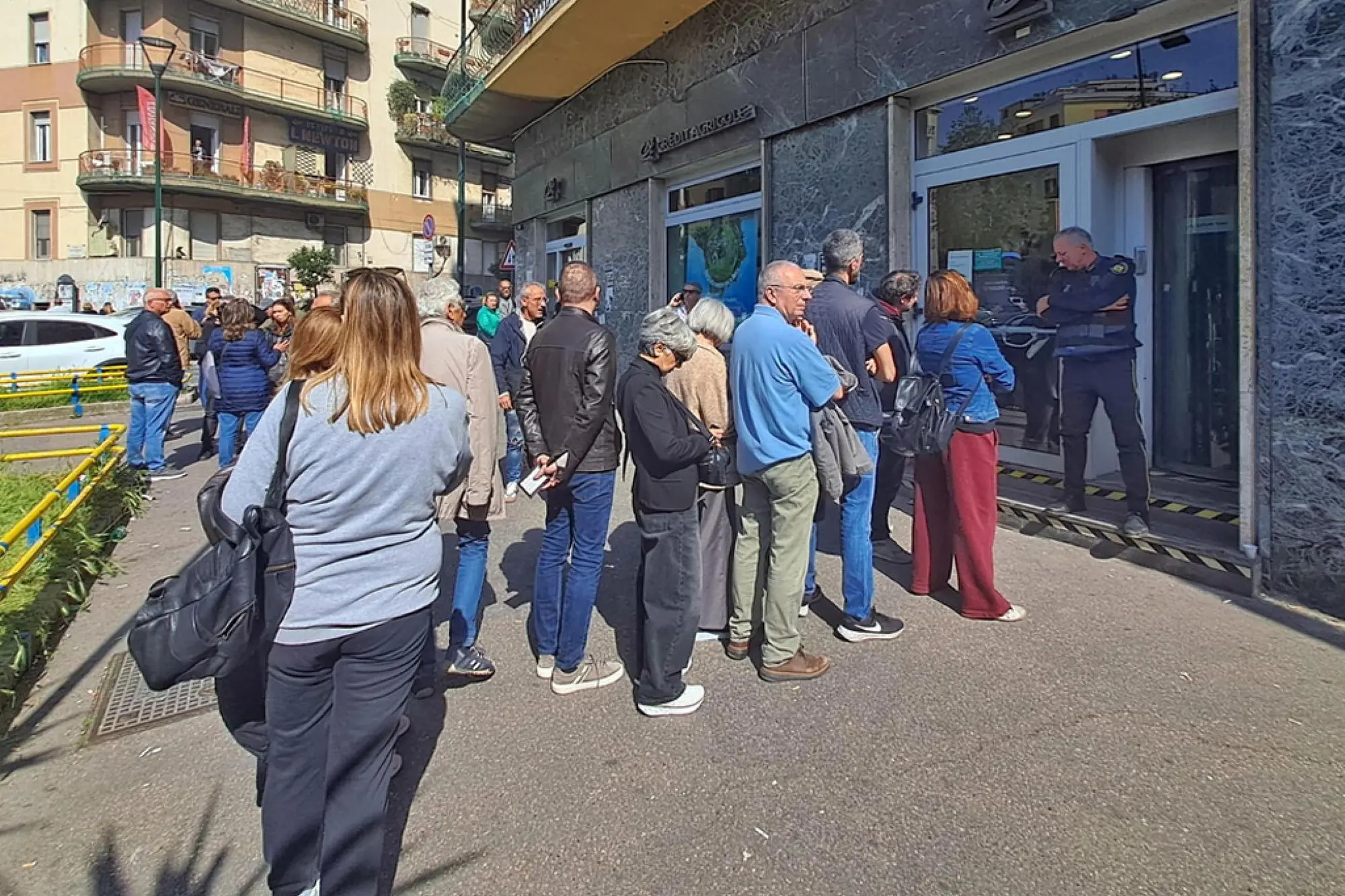 Fila dei possessori delle cassette di sicurezza e correntisti davanti alla banca della Credite Agricole di piazza Medaglie d'Oro (Ansa)