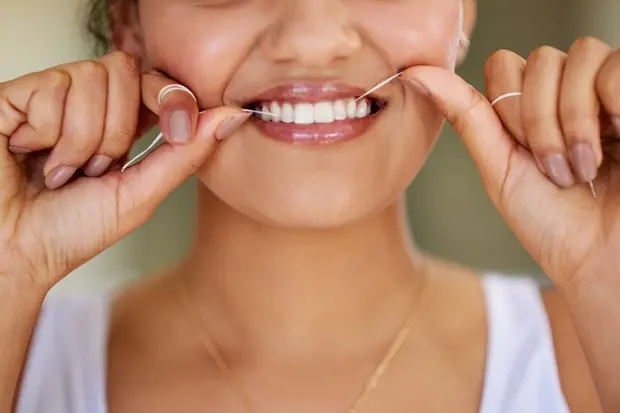 La pulizia dei denti con il filo interdentale