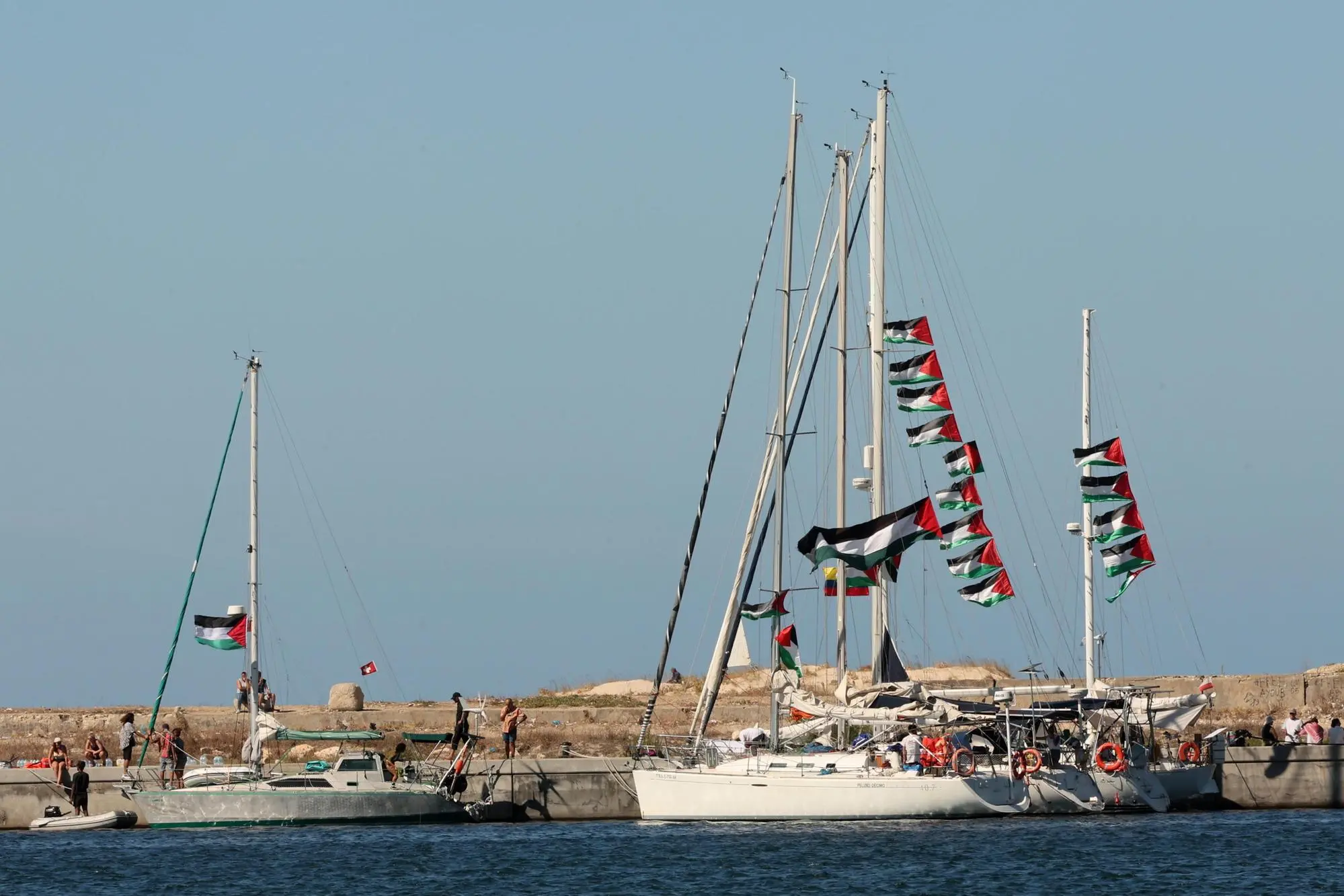 epa12373743 Palestinian fags fly aboard boats of the Global Sumud Flotilla (GSF) before their departure from the port of Bizerte, northern Tunisia, 13 September 2025. The GSF flotilla is an international maritime initiative that began sailing in August 2025 en route to Gaza, aiming to break the Israeli blockade and deliver vital aid to the Gaza Strip. EPA/MOHAMED MESSARA