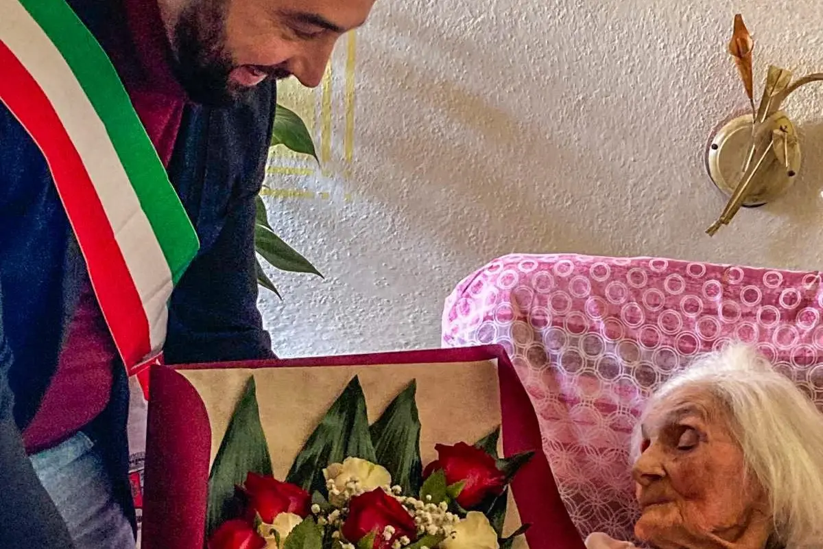 La nonnina riceve i fiori dal sindaco (foto Serreli)