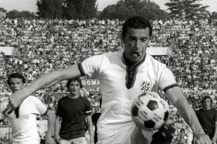 Gigi Riva nel 1974 con la maglia del Cagliari in azione durante una partita con la Roma