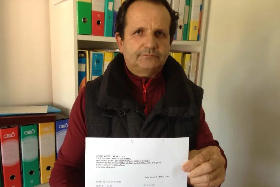 Il signor Congiu mostra il referto medico "incriminato"