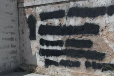 Le scritte di morte cancellate sul muro del cimitero di Oliena (foto L'Unione Sarda)