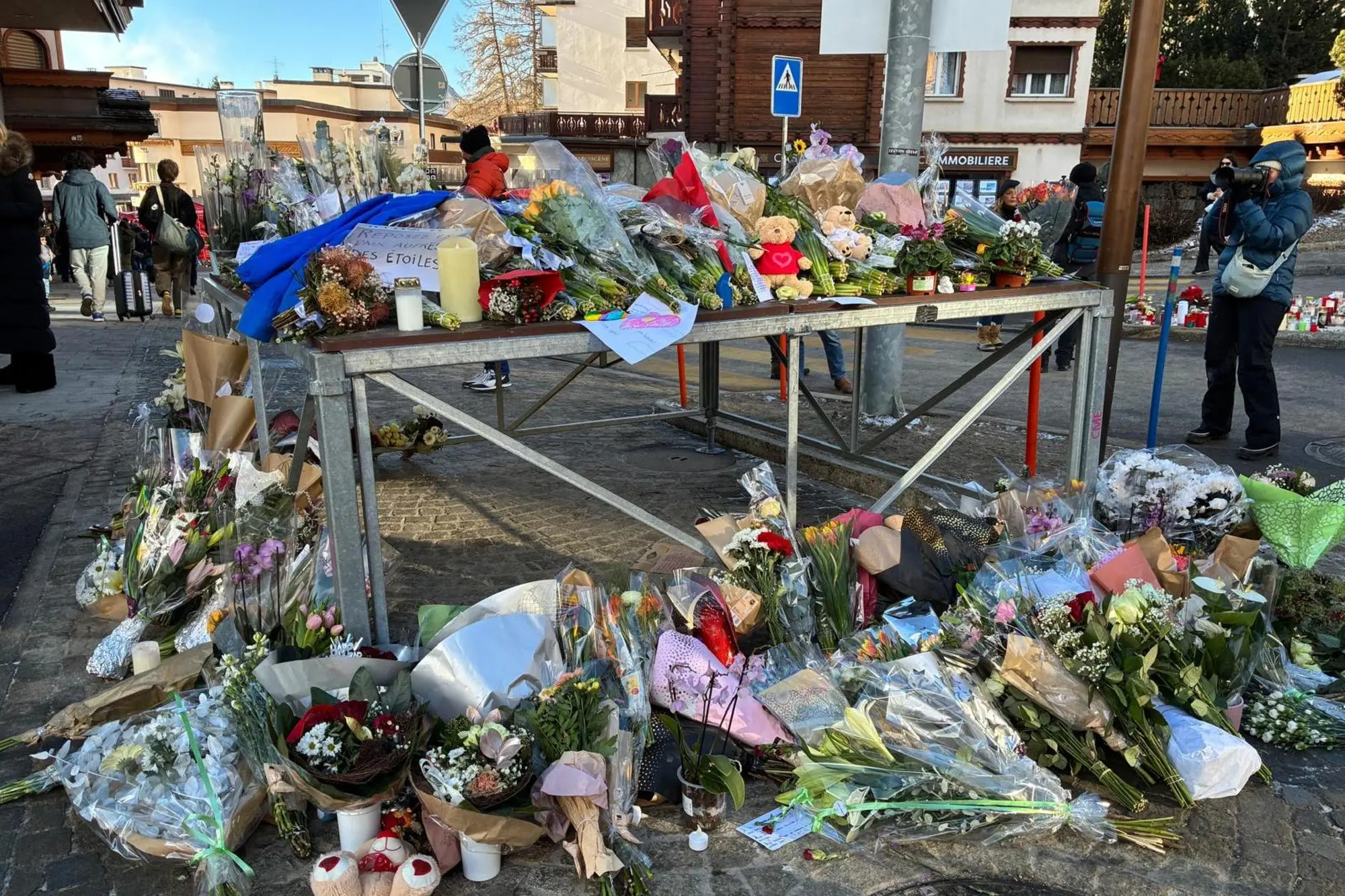 Crans Montana, fiori e messaggi di fronte al bar Le Constellation (foto Ansa)