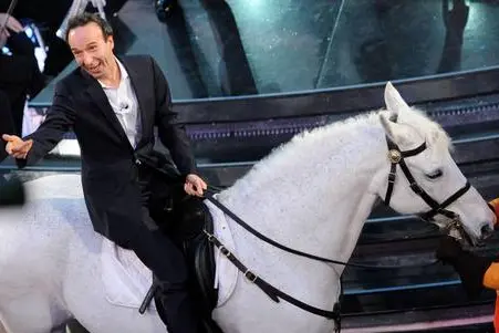 epa02588624 Italian actor and director Roberto Benigni performs sits on a white horse as he performs during the 61st Sanremo Italian Song Festival at the Ariston Theater, in Sanremo, Italy, 17 February 2011. The festival runs from 15 to19 February. EPA/CLAUDIO ONORATI