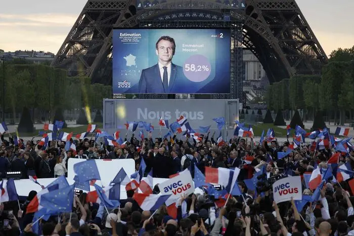TOPSHOT - Supporters react after the victory of French President and La Republique en Marche (LREM) party candidate for re-election Emmanuel Macron in France's presidential election, at the Champ de Mars, in Paris, on April 24, 2022. (Photo by Ludovic MARIN / AFP)