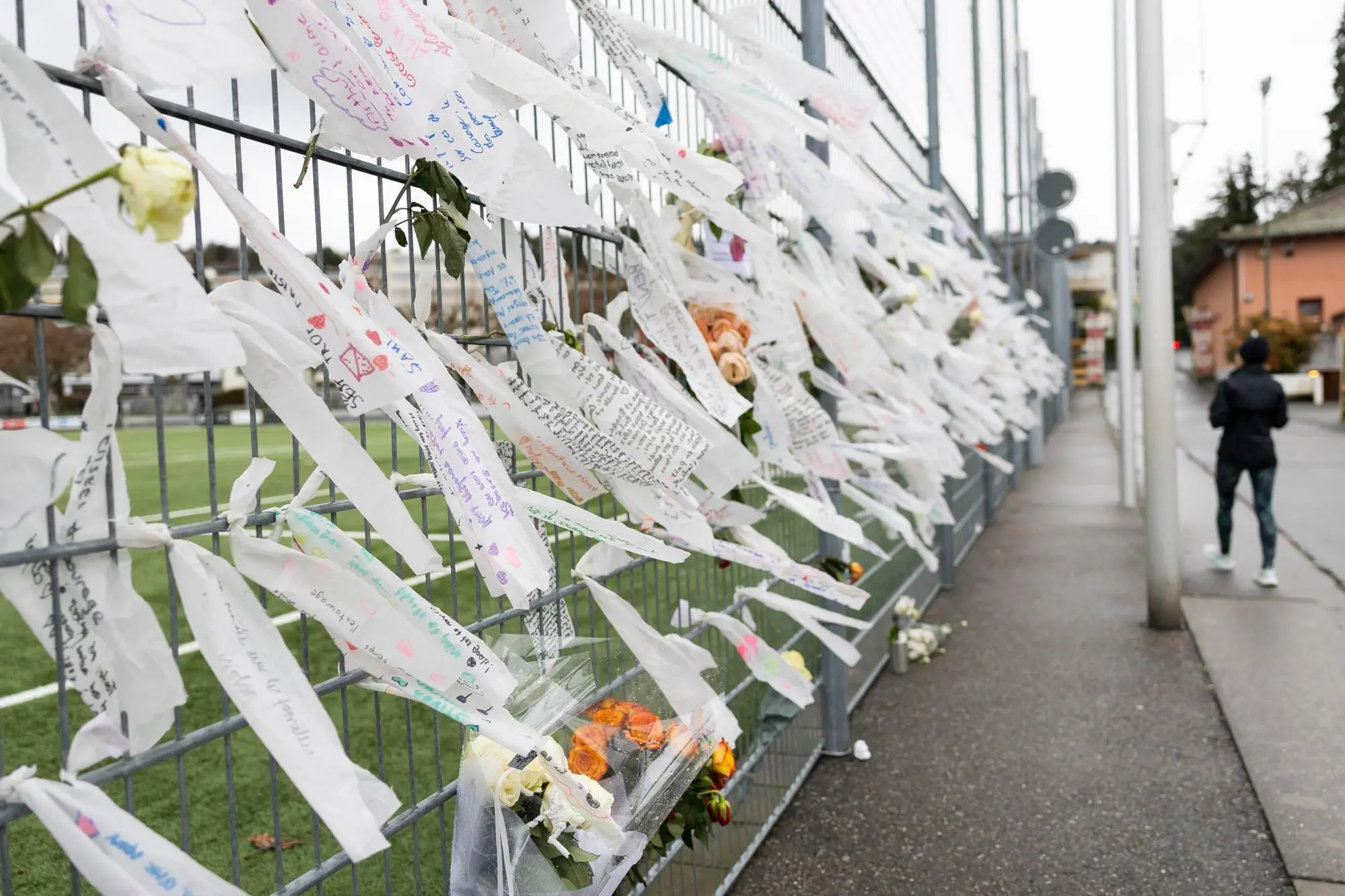 epa12640026 Flowers and messages are placed in tribute to the young members of FC Lutry who died in Crans-Montana following the fire at the 'Le Constellation' bar, at the football stadium in Lutry, Switzerland, 10 January 2026. 40 people mostly teenagers lost their lives and 116 were severely injured in the fire at the bar 'Le Constellation' on New Year's celebration in the Swiss Alps resort of Crans-Montana. EPA/CYRIL ZINGARO