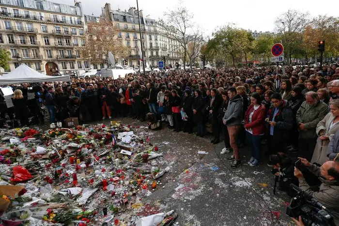 Thousands of people observe a minute of silence near the Bataclan in Paris, France, 16 November 2015. More than 130 people were killed in a series of attacks in Paris on 13 November, according to French officials. Eight assailants were killed, seven when they detonated their explosive belts, and one when he was shot by officers, police said. French President Francois Hollande says that the attacks in Paris were an 'act of war' carried out by the Islamic State extremist group. ANSA/LAURENT DUBRULE