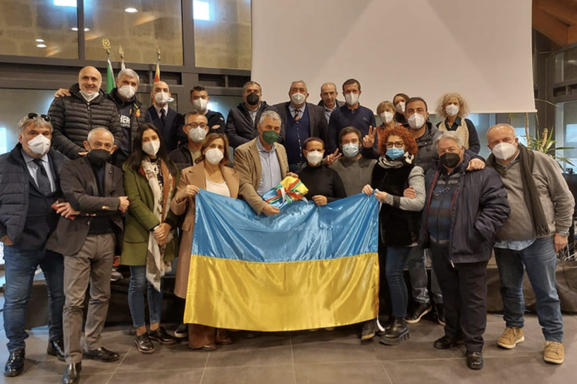 Il Consiglio comunale attorno alla bandiera dell'Ucraina cucita da Maddalena Soro (foto Fiori)