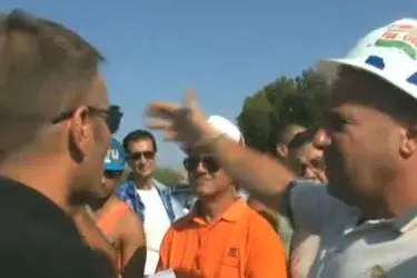 In un fermo immagine del Tg di Videolina un confronto serrato tra un turista e uno dei rappresentanti degli operai Alcoa