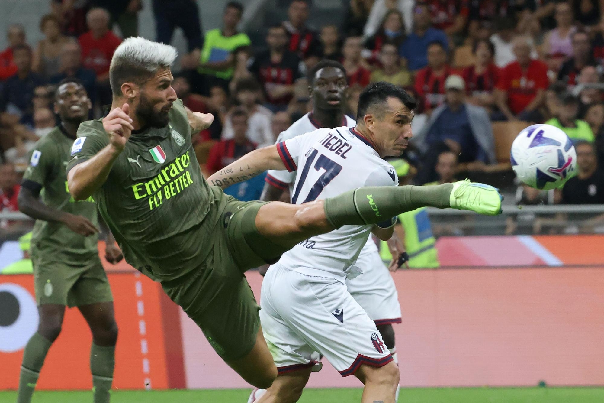 AC Milan's Olivier Giroud (L) scores against Bologna’s Gary Medel goal of 2 to 0 during the Italian serie A soccer match between AC Milan and Bologna at Giuseppe Meazza stadium in Milan, 27 August 2022. ANSA / MATTEO BAZZI