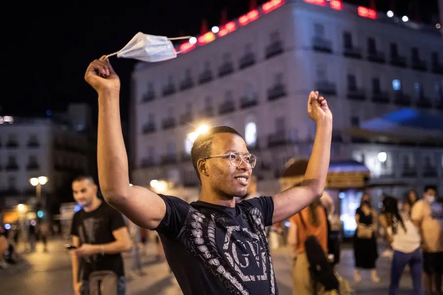 Un uomo sventola la mascherina a Puerta del Sol, nel cuore di Madrid