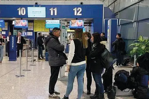 Passeggeri ai banchi dell’accettazione all’aeroporto di Elmas (foto L'Unione Sarda)