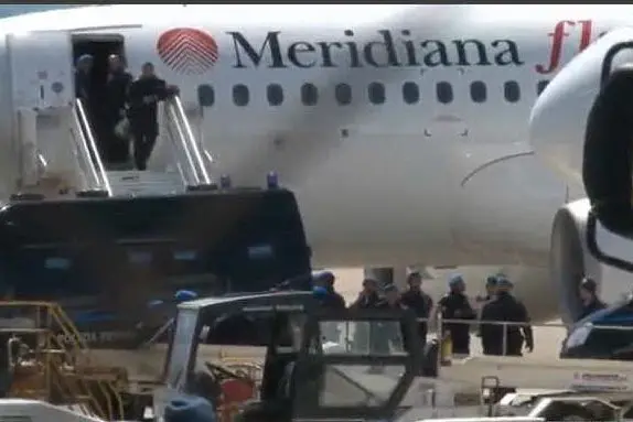 Gli agenti della Polizia penitenziaria presidiano l'aereo