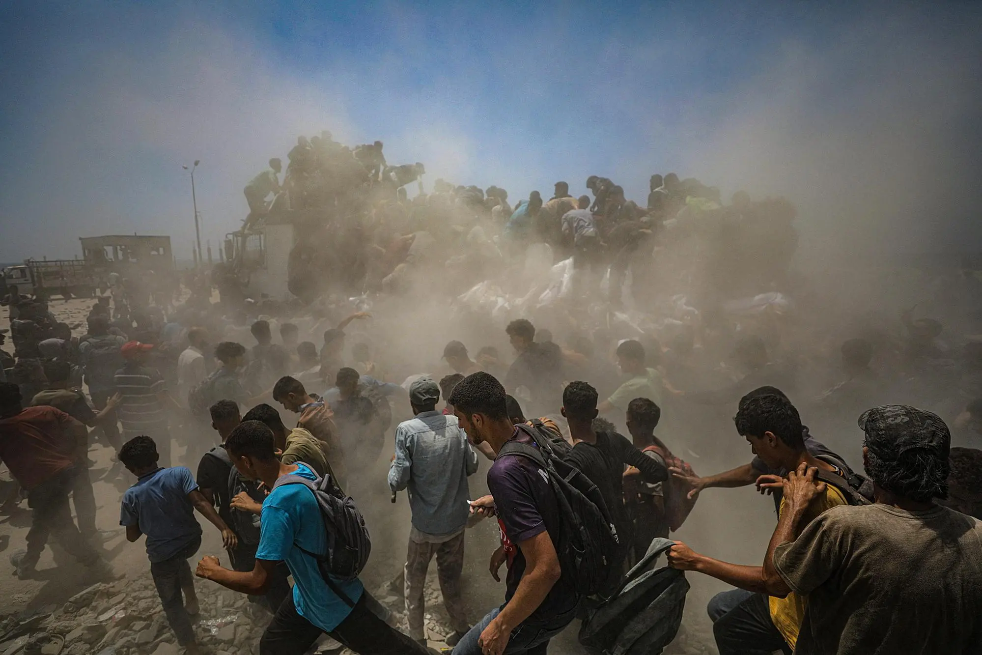 epa12266174 Internally displaced Palestinians try to grab bags of flour from an aid truck near a food distribution point in Zikim, northern Gaza Strip, 27 July 2025. The Israeli army declared a 'tactical pause' in military operations in parts of the Gaza Strip on 27 July, to facilitate the safe passage of humanitarian aid convoys. More than 130 Palestinians, the majority of whom children, have died of malnutrition in the Gaza Strip, the Palestinian Ministry of Health said on 27 July. EPA/MOHAMMED SABER