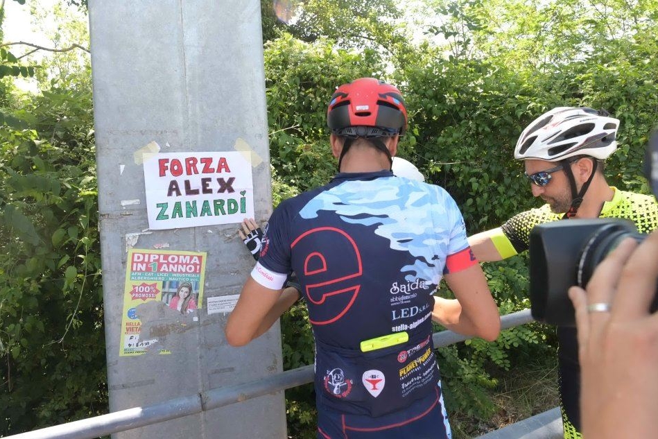 Un gruppo di ciclisti espone un cartello nelle zone dell'incidente di Zanardi (foto Ansa)