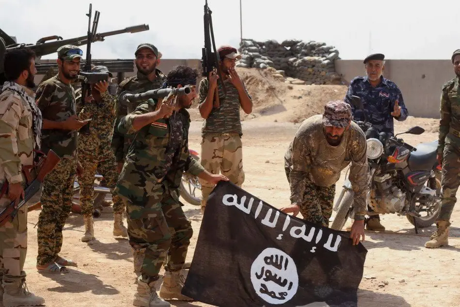 Soldati iracheni con una bandiera catturata ai miliziani Isis