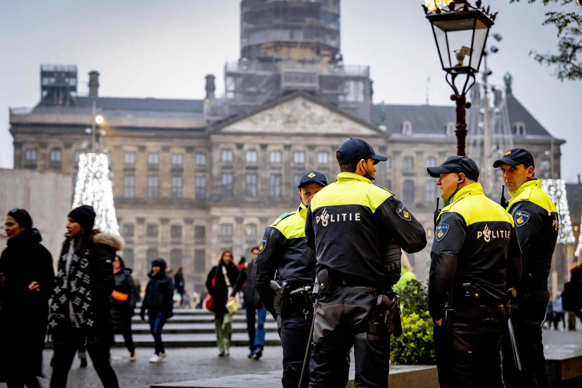 epa11711977 People walk past a police car as officers stand guard on Dam Square in Amsterdam, Netherlands, 09 November 2024. Extra security measures are in place in Amsterdam due to tensions and violence surrounding supporters of Israeli soccer club Maccabi Tel Aviv. There is a ban on demonstrations throughout the capital this weekend. The entire city has also been designated a security risk area. EPA/ROBIN UTRECHT