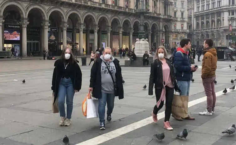 Turiste a Milano con la mascherina (Foto L'Unione Sarda)