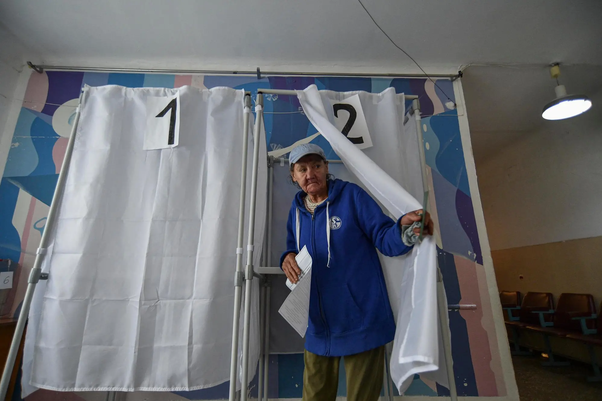 epa10209346 A woman holds her ballot during voting in a so-called 'referendum' on the joining of Russian-controlled regions of Ukraine to Russia, at a polling station in Melitopol, Zaporizhzhia region, southeastern Ukraine, 27 September 2022. From 23 to 27 September, residents of the self-proclaimed Luhansk and Donetsk People's Republics as well as the Russian-controlled areas of the Kherson and Zaporizhzhia regions of Ukraine voted on a so-called 'referendum' to join the Russian Federation. On 24 February 2022 Russian troops entered the Ukrainian territory in what the Russian president declared a 'Special Military Operation', starting an armed conflict that has provoked destruction and a humanitarian crisis. EPA/STRINGER