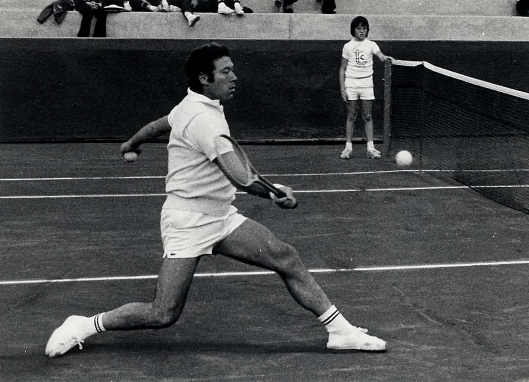 Nicola Pietrangeli effettua una volèe di diritto nel campo entrale del tennis club Cagliari di Monte Urpinu: il raccattapalle è Angelo Binaghi, attuale presidente della Federtennis (foto Archivio Unione Sarda)
