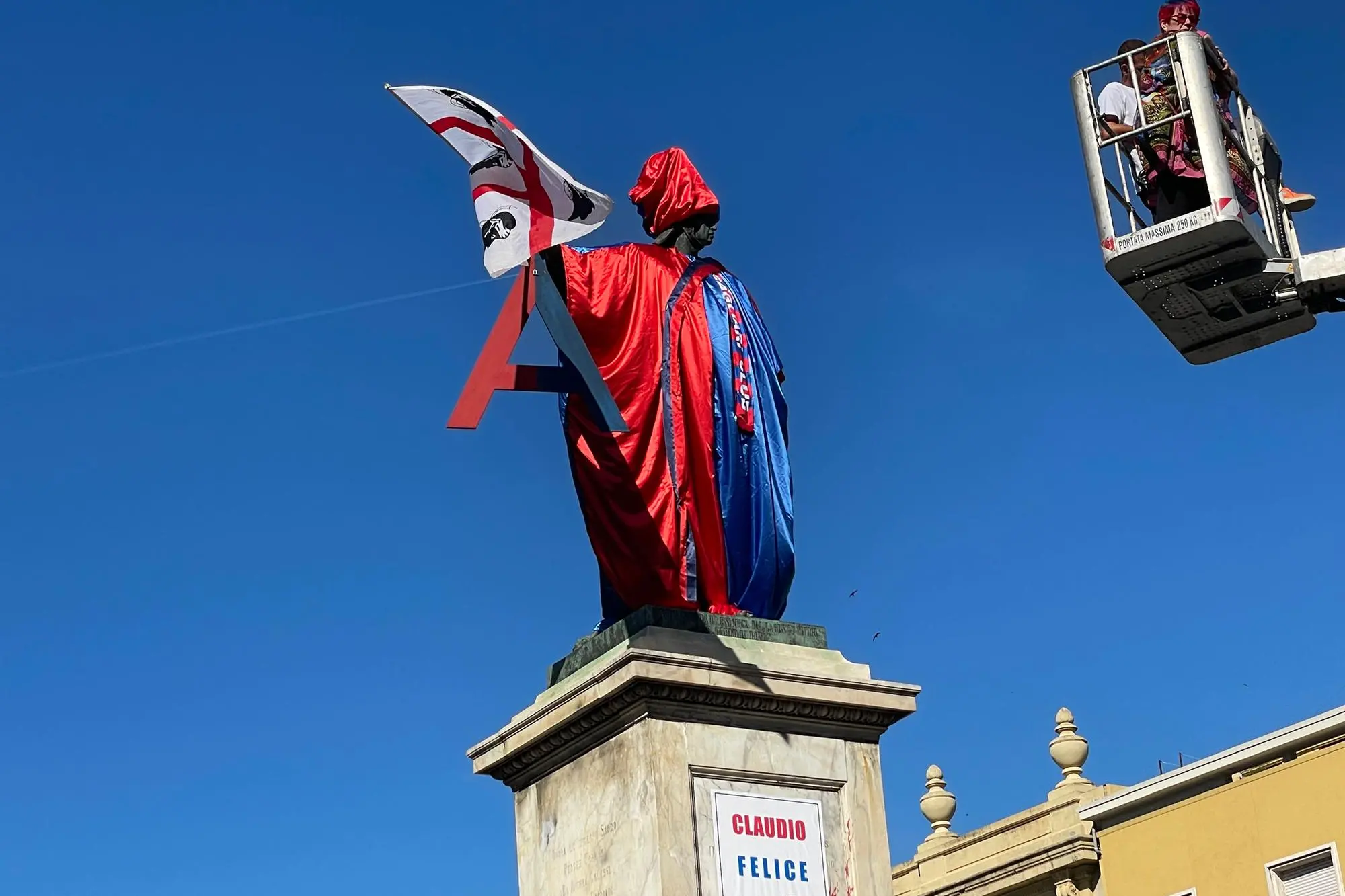 La statua di Carlo Felice vestita di rossoblù con lo striscione dedicato a Claudio Ranieri (foto Spignesi)