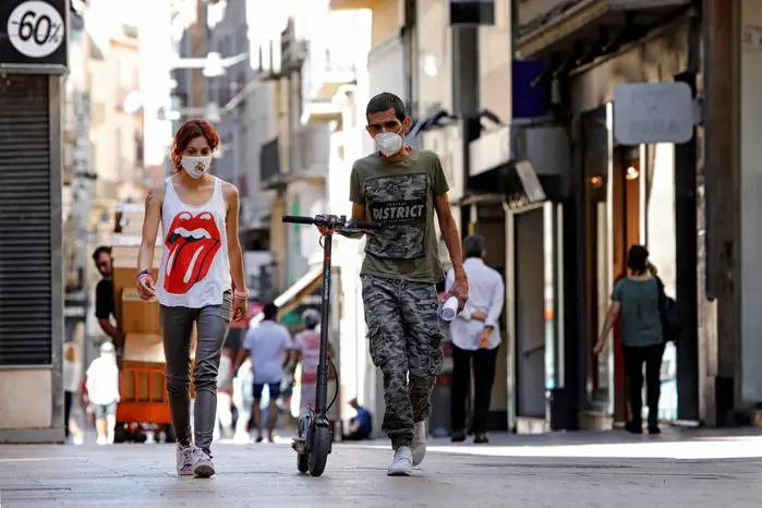 Due persone a passeggio nella città spagnola di Lleida (Ansa)