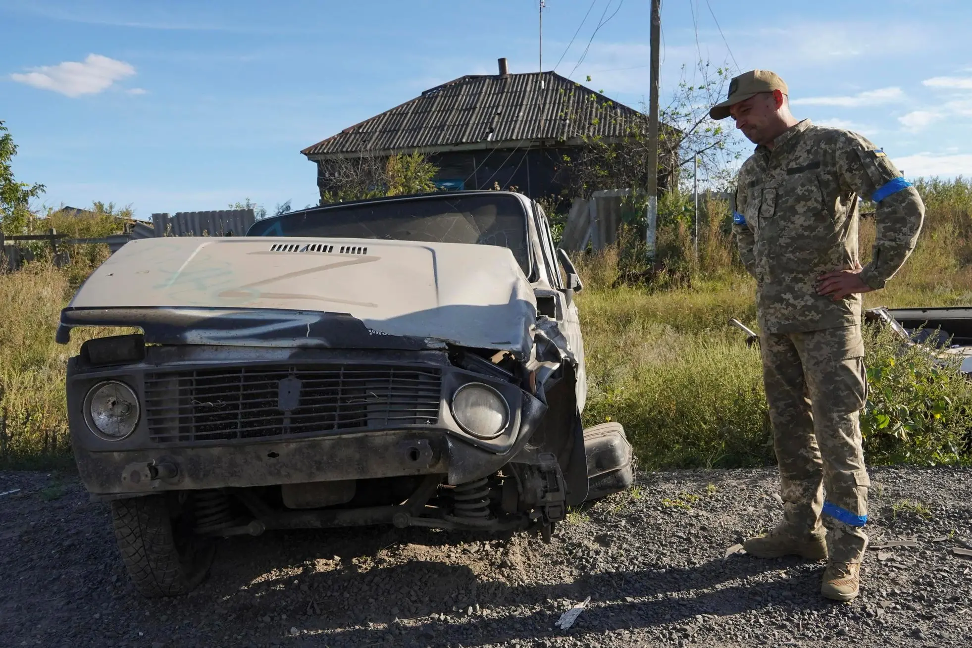 epa10174215 A Ukrainian serviceman stands near a civilian car with the letter Z, often painted on Russian military vehicles in Ukraine, which was captured and used by Russian soldiers when they controlled that territory, which was retaken by Ukrainian troops two days ago, in the village of Grakovo in Kharkiv's surroundings, Ukraine, 09 September 2022. Kharkiv and surrounding areas have been the target of heavy shelling since February 2022, when Russian troops entered Ukraine starting a conflict that has provoked destruction and a humanitarian crisis. EPA/VASILIY ZHLOBSKY