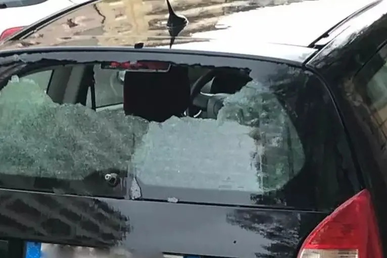 Il vetro rotto dell'auto (foto Ansa)