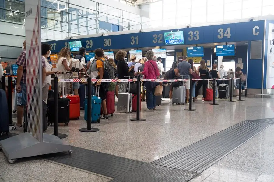 Passeggeri ai banchi dei check in dell'aeroporto di Cagliari (foto archivio L'Unione Sarda)