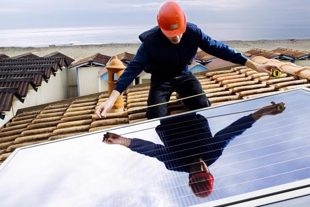 Un operaio installa pannelli solari fotovoltaici in una foto di archivio