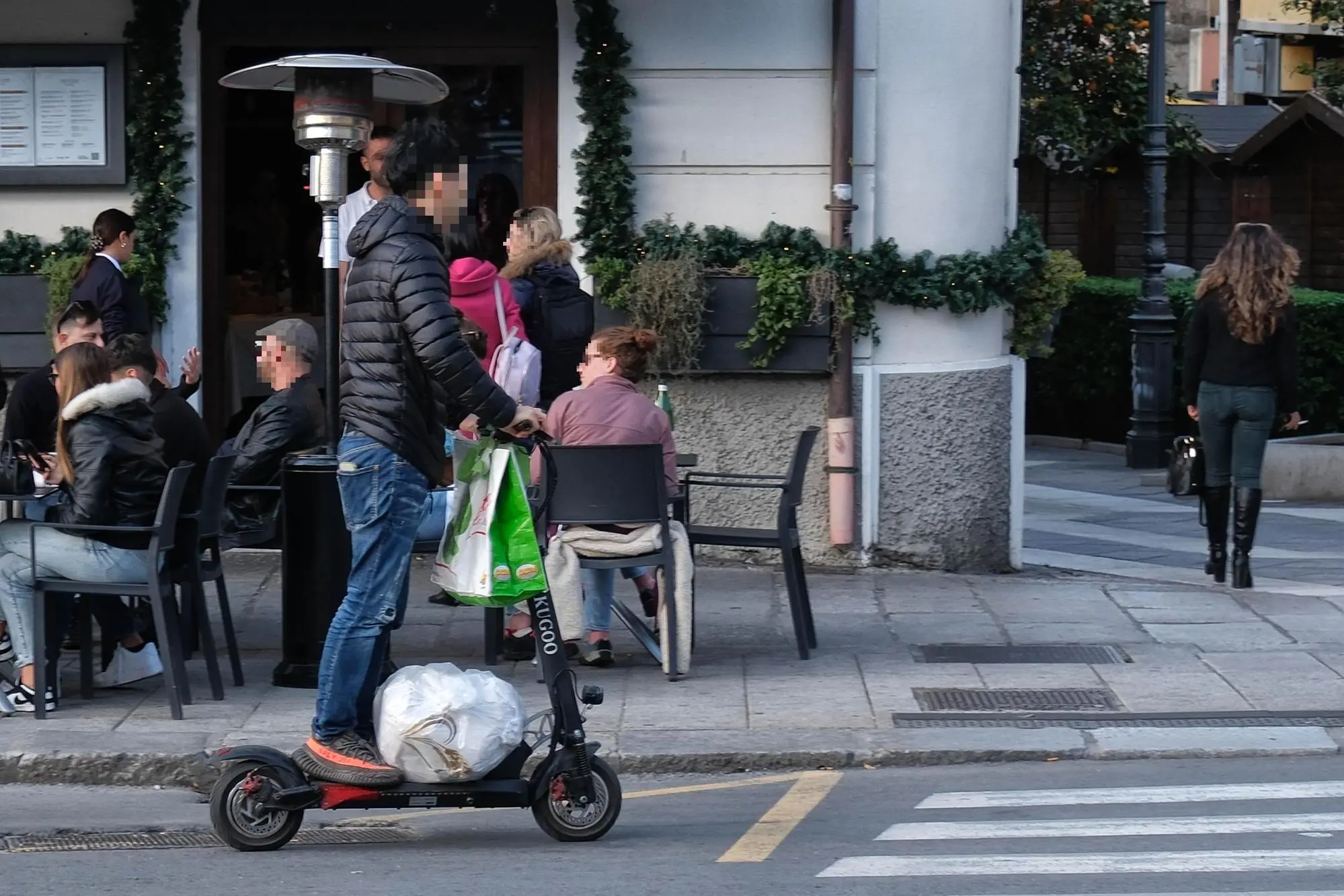 Un uomo in monopattino trasporta pacchi e buste (foto di Giuseppe Ungari)