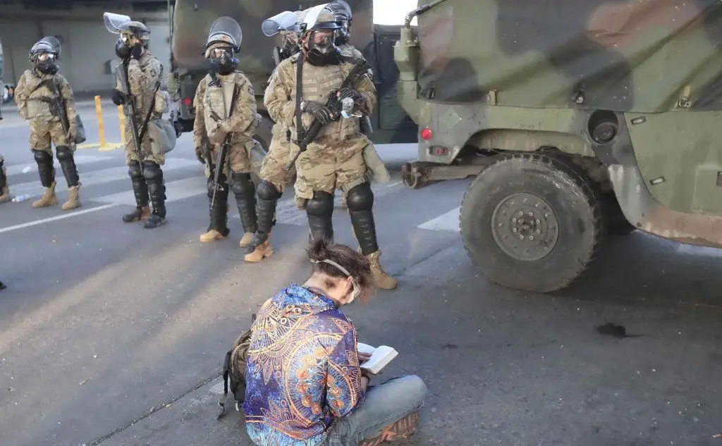 Un manifestante seduto a terra davanti alla Guardia nazionale (Ansa - Maury)