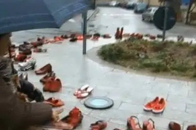 Una signora posa le sue scarpe rosse in piazza Sa Serra, a Gavoi
