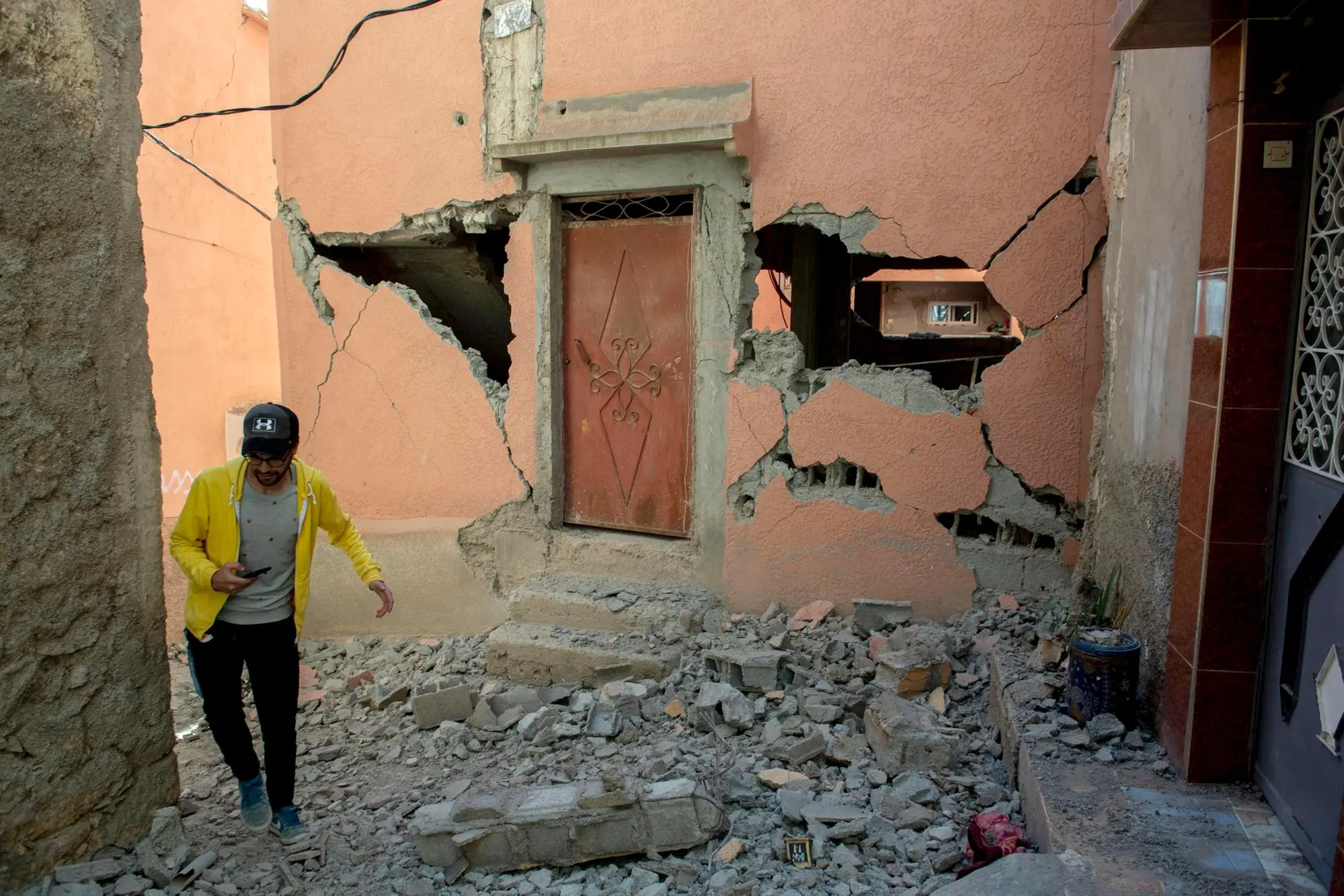 epa10850165 A person walks over debris next to a damaged building following an earthquake in Marrakesh, Morocco, 09 September 2023. A powerful earthquake that hit central Morocco late 08 September, killed at least 820 people and injured 672 others, according to a provisional report from the country's Interior Ministry. The earthquake, measuring magnitude 6.8 according to the USGS, damaged buildings from villages and towns in the Atlas Mountains to Marrakesh. EPA/JALAL MORCHIDI