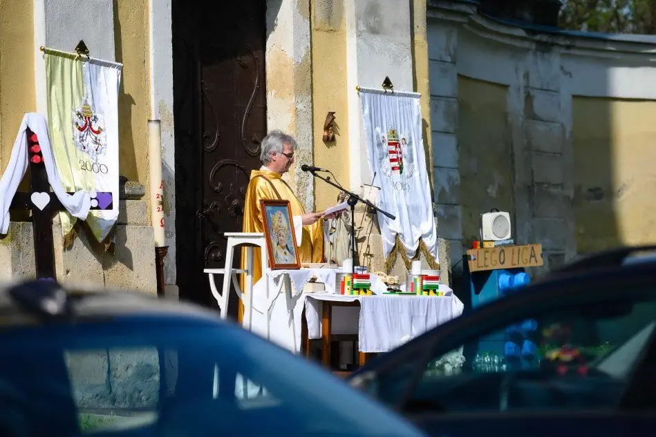Un parroco in Ungheria celebra la messa fuori dalla chiesa (Ansa)