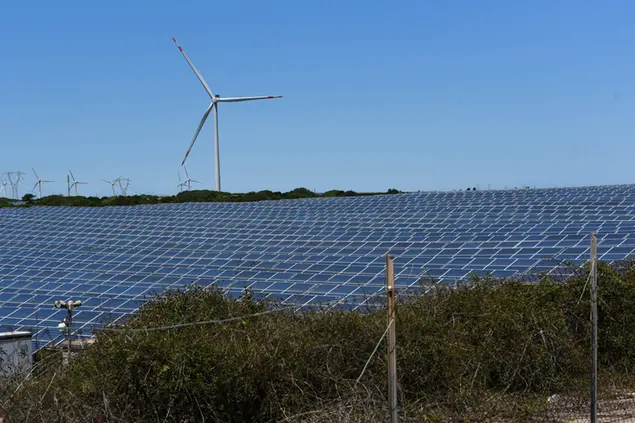 Una pala eolica e un campo fotovoltaico