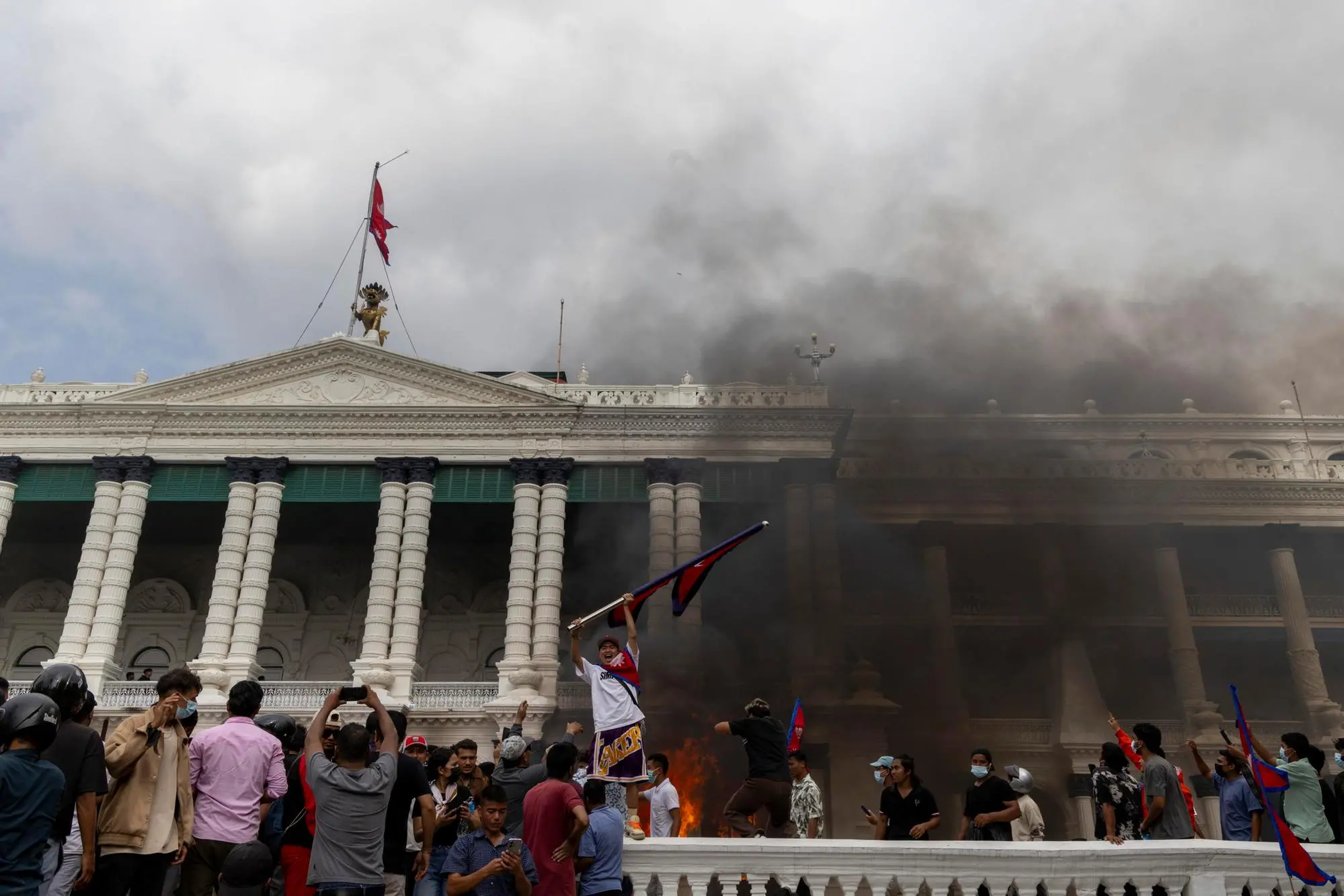 epa12364615 Protesters gather in front of the Singha Durbar palace, which houses government and parliament buildings, during violent demonstrations in Kathmandu, Nepal, 09 September 2025. At least 19 people were killed and dozens injured on 08 September during demonstrations against corruption and a government social media ban. EPA/NARENDRA SHRESTHA