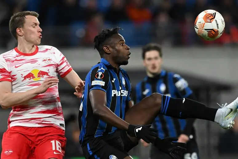 epa09876549 Lukas Klostermann (L) of Leipzig in action against Duvan Zapata of Atalanta during the UEFA Europa League quarter final, first leg soccer match between RB Leipzig and Atalanta BC in Leipzig, Germany, 07 April 2022. EPA/FILIP SINGER