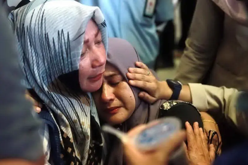 Il dolore dei familiari delle vittime della tragedia aerea indonesiana (Ansa)