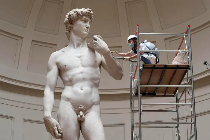 Una restauratrice effettua una spolveratura del David di Michelangelo per la prossima apertura del museo . 27 Maggio 2020 Firenze ANSA/CLAUDIO GIOVANNINI