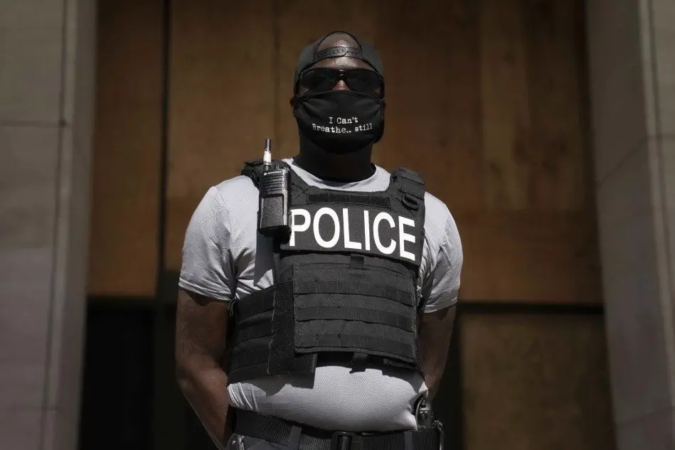 Un poliziotto di colore si unisce alle proteste negli Usa (Ansa)