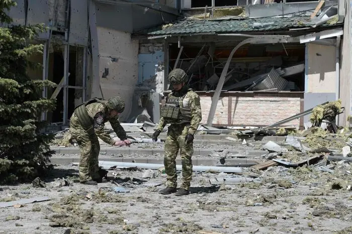 Military investigators work on the site of the damaged building housing the Paradise restaurant following a strike in Donetsk, Russian-controlled Ukraine, on May 11, 2024, amid ongoing Russian-Ukrainian conflict. A missile strike on May 11, 2024, on the restaurant in Donetsk, eastern Ukraine, killed three people and wounded eight, the head of the region's Russian-backed administration Denis Pushilin wrote on Telegram. Pushilin said that there were two strikes by US HIMARS precision rocket launchers, which hit the restaurant and damaged the roof of a partially-constructed building nearby. (Photo by STRINGER / AFP)