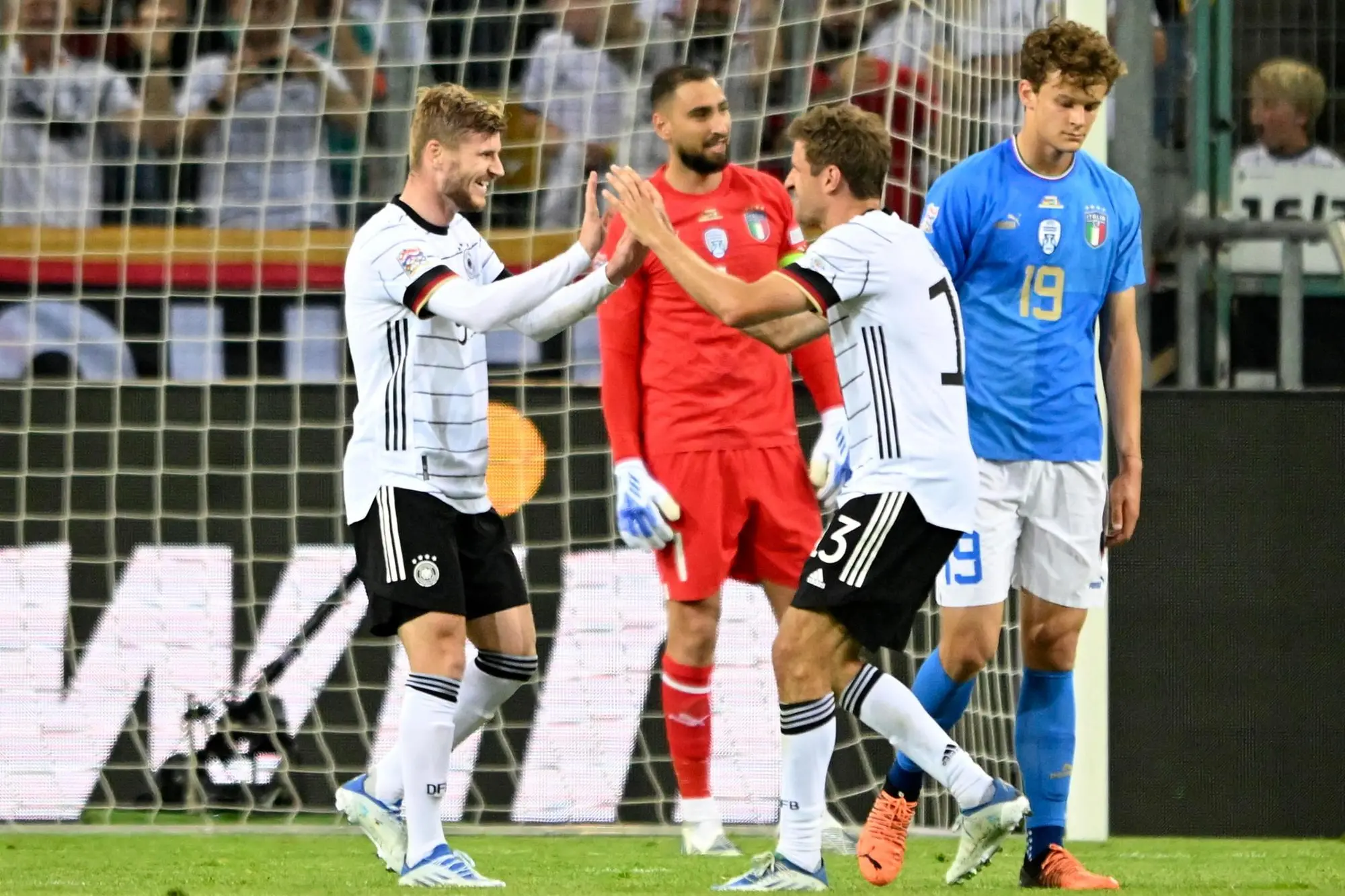 epa10013386 Timo Werner (L) of Germany celebrates with teammate Thomas Mueller (2-R) after scoring the 5-0 lead against Italy's goalkeeper Gianluigi Donnarumma (back) during the UEFA Nations League soccer match between Germany and Italy in Moenchengladbach, Germany, 14 June 2022. EPA/SASCHA STEINBACH