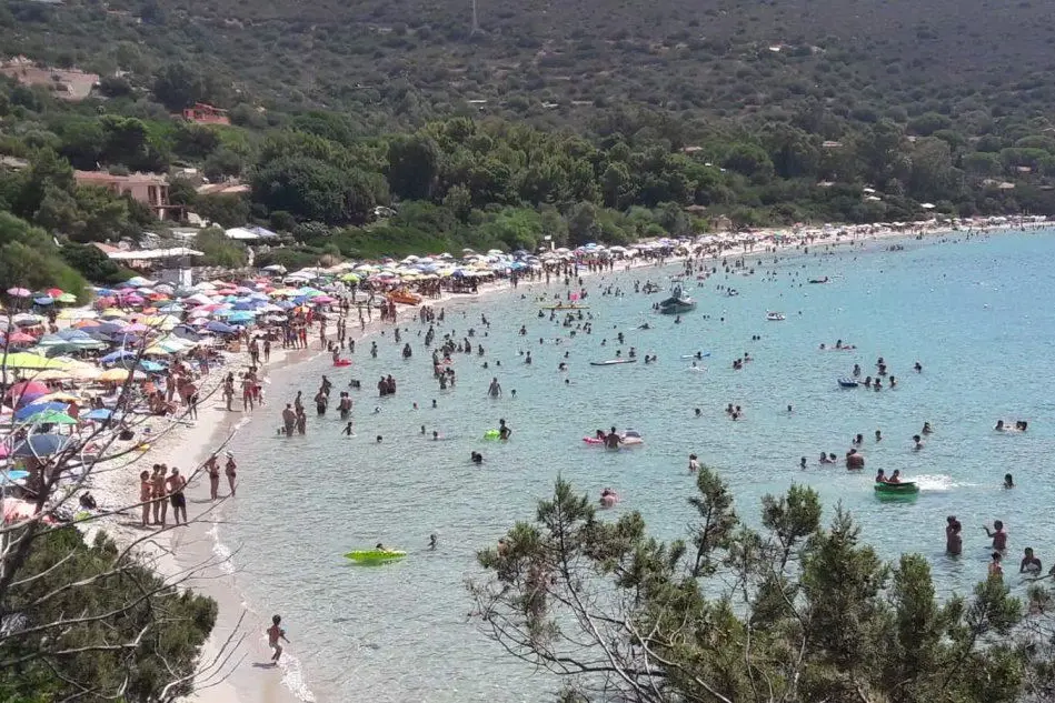 La spiaggia piena di turisti (foto L'Unione Sarda - Serreli)