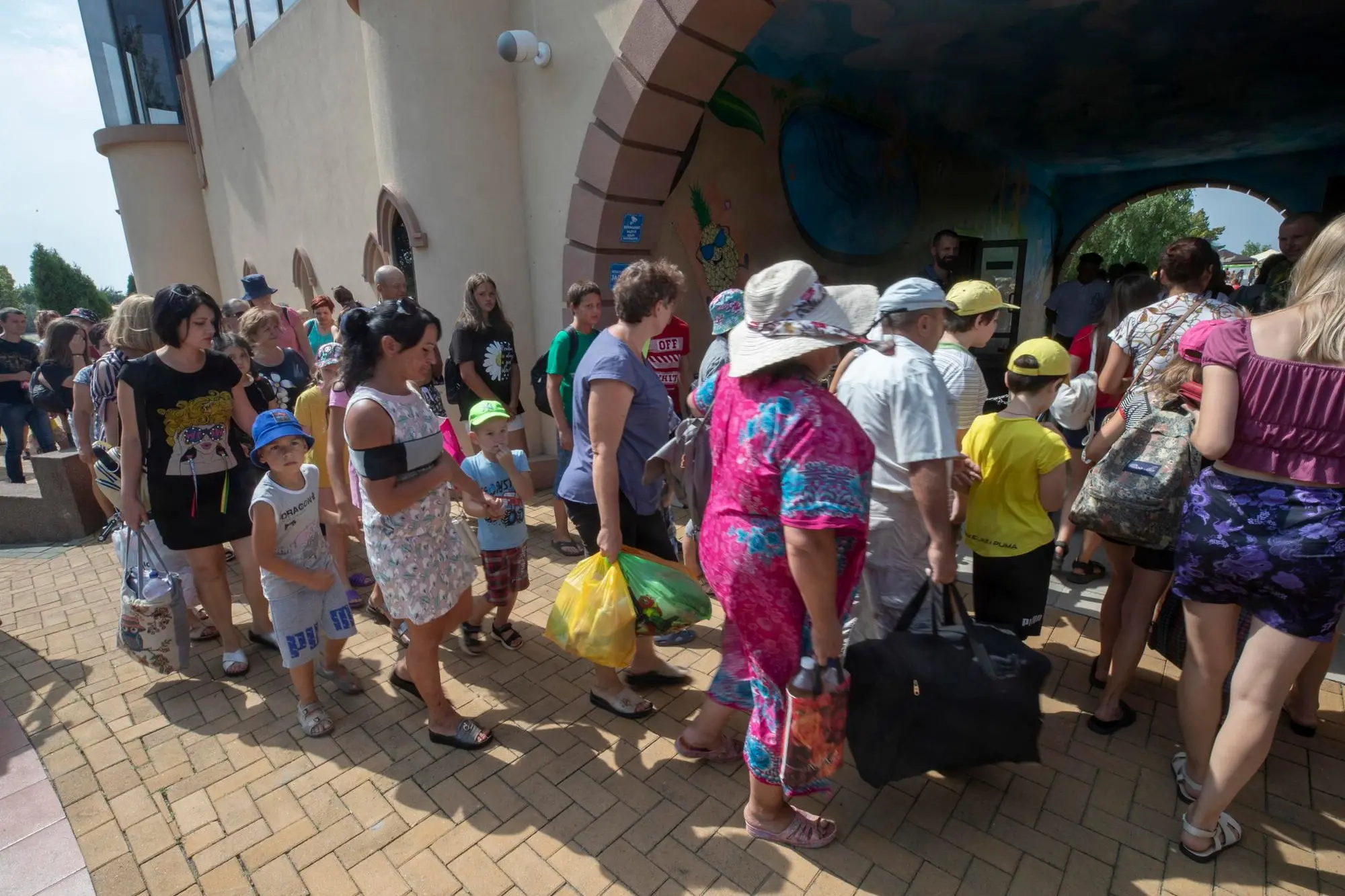 epa10116797 A picture taken during a visit to Berdyansk organised by the Russian military shows IDPs enter the water park for their free rest in Berdyansk, Zaporizhia region, Ukraine, 11 August 2022 (Issued 12 August 2022). The city of Berdyansk is located on the territory controlled by the troops of the Russian Federation and the city is administered by the Military-Civilian Administration controlled by Russia. Berdyansk is a large resort city on the shores of the Azov Sea. Thousands of vacationers visited it in the summer. This year, due to the conflict between Russia and Ukraine, the city's beaches and hotels are without tourists. City businessmen place some thousand IDPs from Mariupol and other parts of Ukraine in their recreation centres providing food, accommodation and rehabilitation for people. For IDPs with children, the city water park operates free of charge. The head of the Zaporizhia region, Yevgeny Balitsky, announced that he had signed an order to hold a referendum on the issue of joining the region to Russia in early September 2022. Twelve headquarters for preparations for a referendum on joining the Russian Federation opened in Berdyansk and Berdyansk district of Zaporizhia region, said the head of the military-civilian administration of Berdyansk and Berdyansk region Alexander Saulenko. On 24 February 2022 Russian troops entered the Ukrainian territory in what the Russian president declared a 'Special Military Operation', starting an armed conflict that has provoked destruction and a humanitarian crisis. EPA/SERGEI ILNITSKY