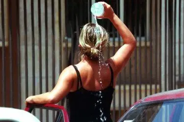 Una donna si rinfresca con dell'acqua ghiacciata