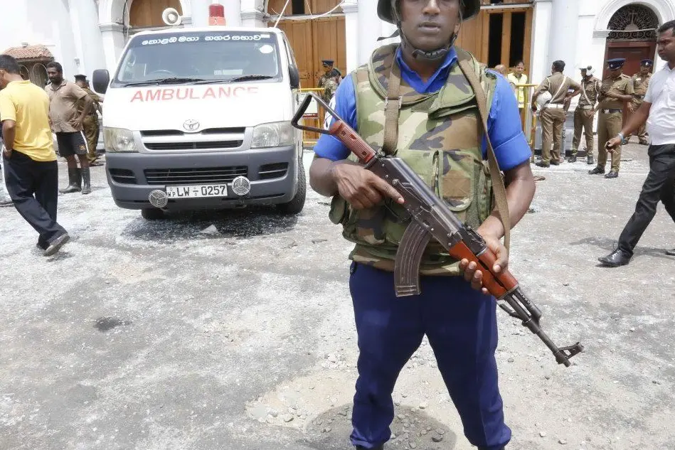Ambulanze e personale di sicurezza a Colombo, una delle città colpite dagli attentatori (Ansa)