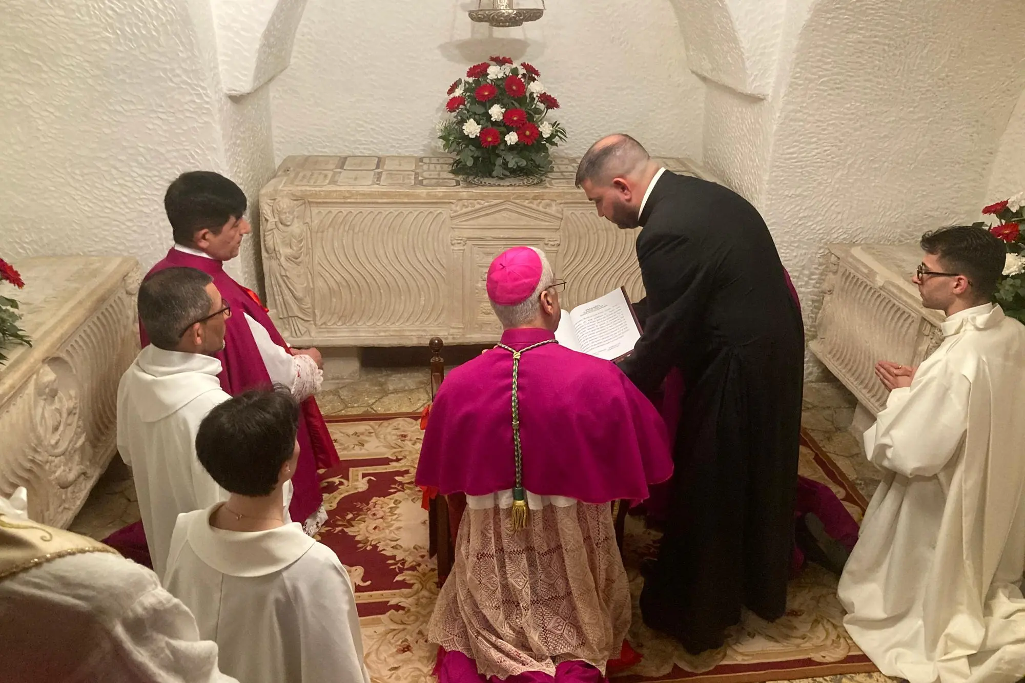 L'inchino dell'arcivescovo Soddu davanti alle tombe dei Martiri (foto Pala)